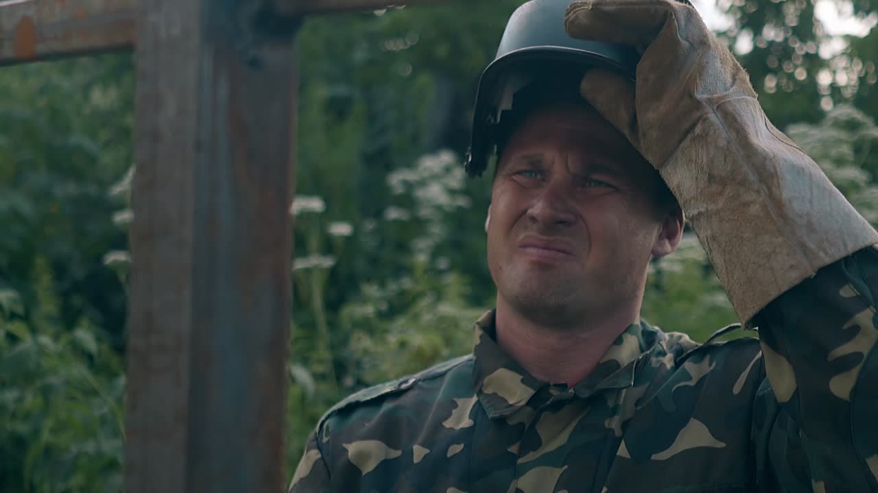 el trabajador se quita la máscara y comprueba la valla metálica terminada