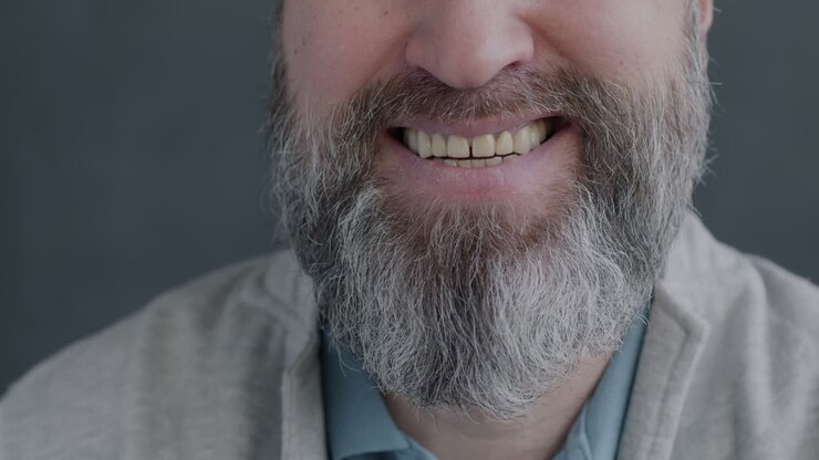 Uomo sorridente con la barba grigia