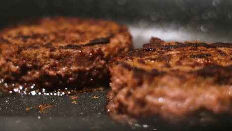 cooking juicy burger patties in a pan