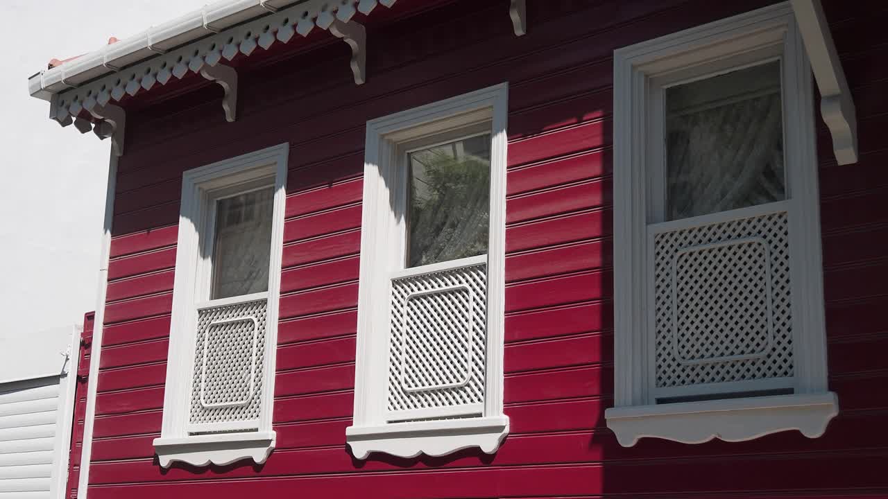 Casa di legno rossa con finiture bianche.