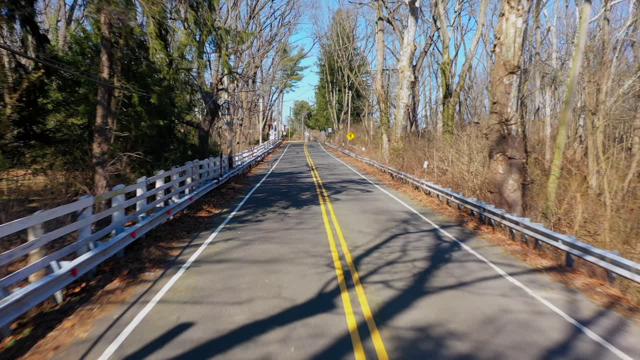 una foto de un dron de ángulo bajo de una carretera rural vacía en un día soleado