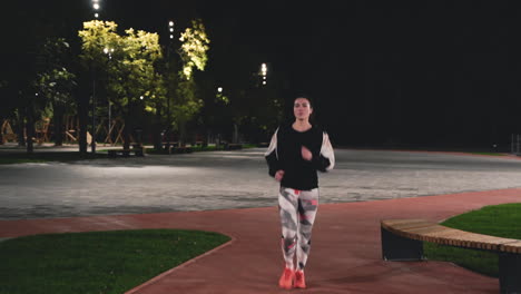 Sportive-Sportswoman-Running-Towards-Camera-In-The-Park-At-Night