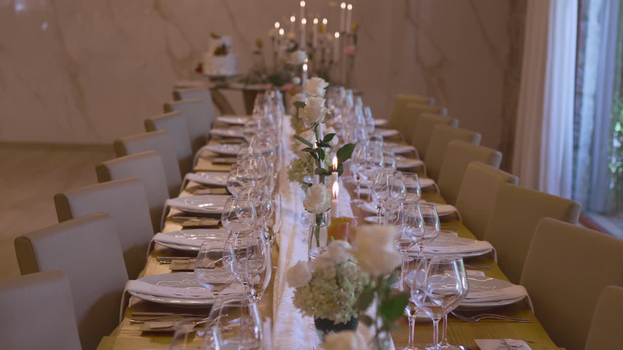 Romantisk borddækning til bryllup med stearinlys, blomster og elegant spisestudsindretning
