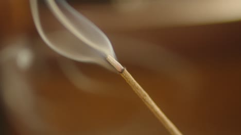 closeup ignited incense smoke burning in focus, spiritual religious prayer