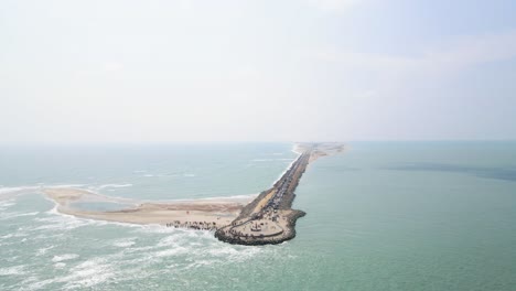 aerial drone shot over dhanushkodi, showcasing the dramatic ending of the last road and its coastal surroundings.