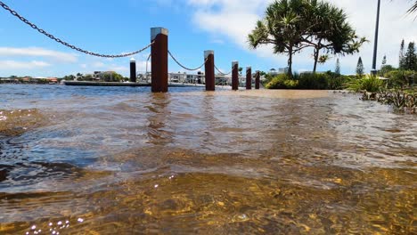 a dog walker turns back as a high tide rises to flood a waterfront footpath