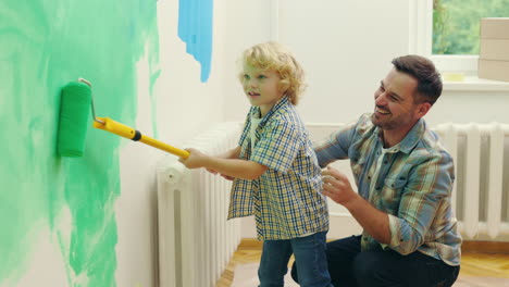 padre e hijo pintando una pared juntos