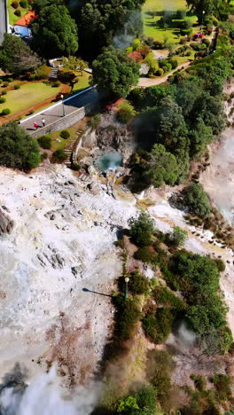 flying above the rocky landscape of volcanic nature. clouds of smoke rise up from the mount. aerial perspective on the beautiful park in the azorean islands, the autonomous region of the azores. vertical video.