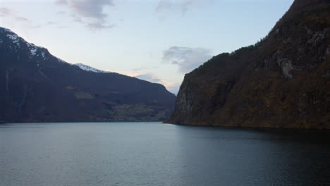 shot of the aurlandsfjorden, sogneflord by undredal village in the fjords with skjerdalsvegen and flenes in background.