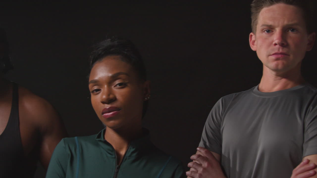 retrato de estudio de un grupo determinado de atletas masculinos y femeninos en entrenamiento de ropa de fitness disparado contra un fondo negro 1