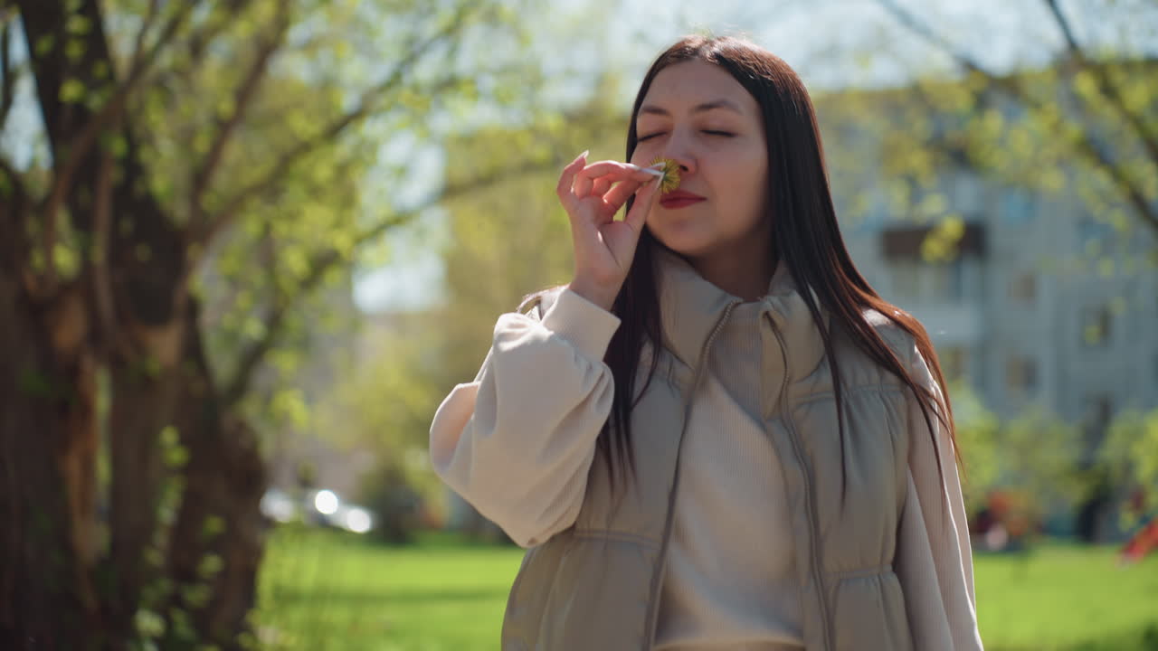 푸른 덮개 아래에서 향기로운 꽃을 음미하는 소녀, 밝은 숲속 환경에서 봄바람을 만끽하는 여성, 나무 사이로 스며드는 햇빛 아래에서 꽃향기를 즐기는 젊은 여성