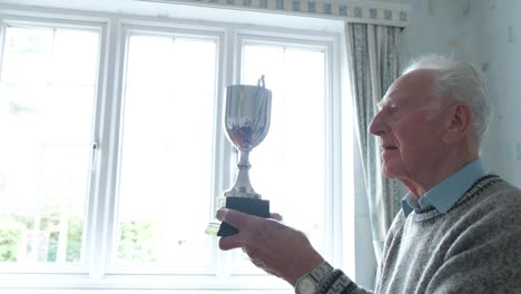 senior caucasian man cleaning his trophy