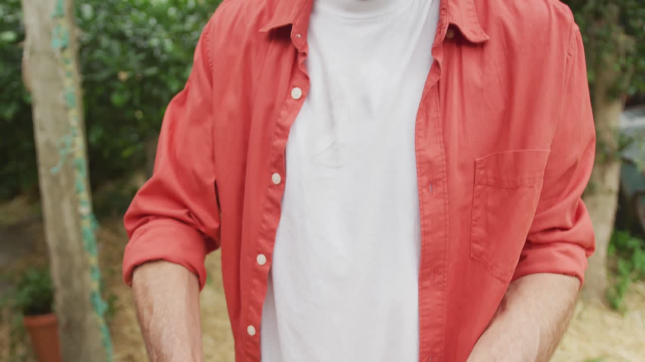 retrato de un hombre caucásico mayor sonriente sosteniendo verduras frescas en el jardín