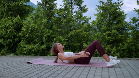 mujer haciendo ejercicios abdominales al aire libre