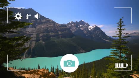 Digital-camera-interface-against-landscape-with-woods,-lake-and-mountains