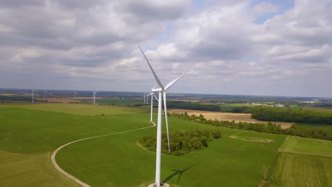 Vista-Aérea-De-Molinos-De-Viento-Y-Tierras-De-Cultivo-En-Un-Pintoresco-Día-De-Verano