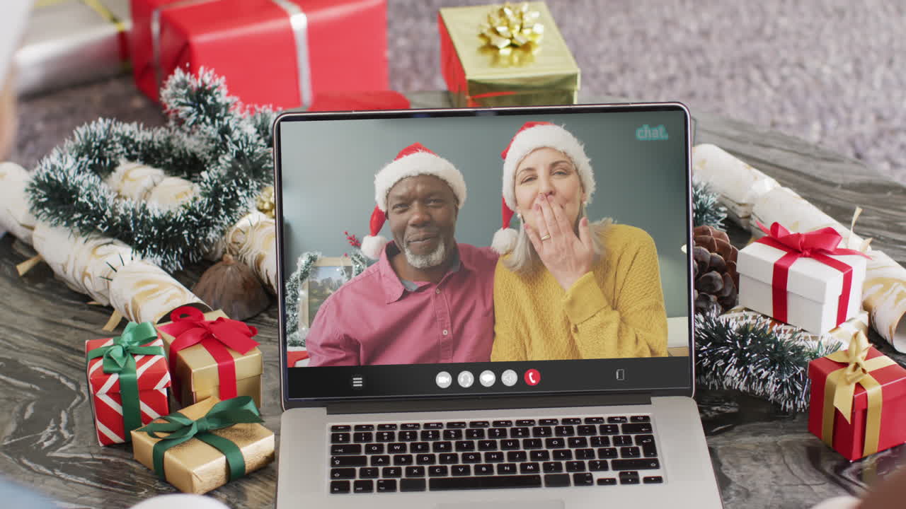 pareja diversa teniendo videoconferencia de navidad con pareja diversa senior