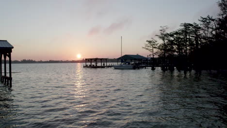 peaceful sunrise over lake with docks, drone shot