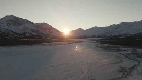 sun shining over snowy landscape in winter in silver city, kluane, yukon. - aerial shot