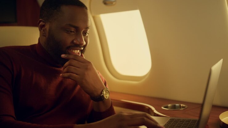 Cheerful man typing keyboard on business travel closeup. African american work