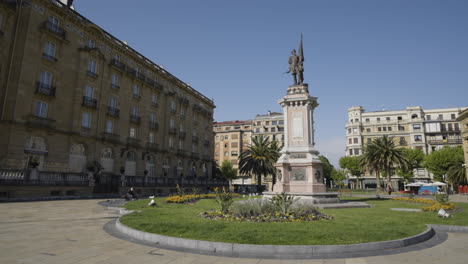 Memorial-statue-in-beautiful-square-of-San-Sebastian-city,-pan-left-view