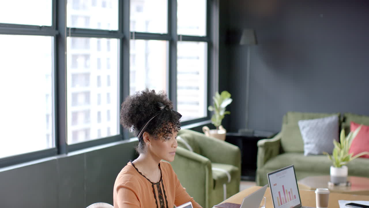 Donna d'affari afroamericana che usa il laptop in ufficio con spazio per il testo