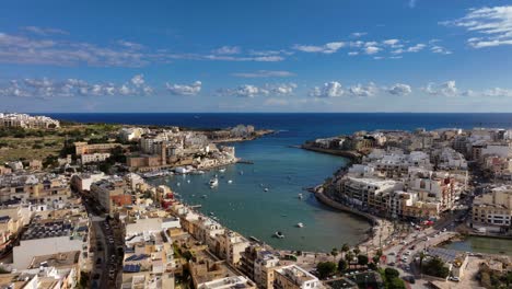 Volando-Sobre-El-Puerto-De-Marsascala-Con-Barcos-Pesqueros-Y-La-Iglesia-Parroquial-De-Marsaskala,-Vista-Aérea