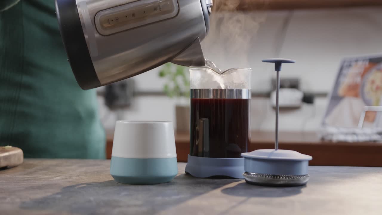 백인 남자가 커피를 만들고 부 ⁇ 에서 스마트폰을 사용하는 중간 섹션, 슬로우 모션