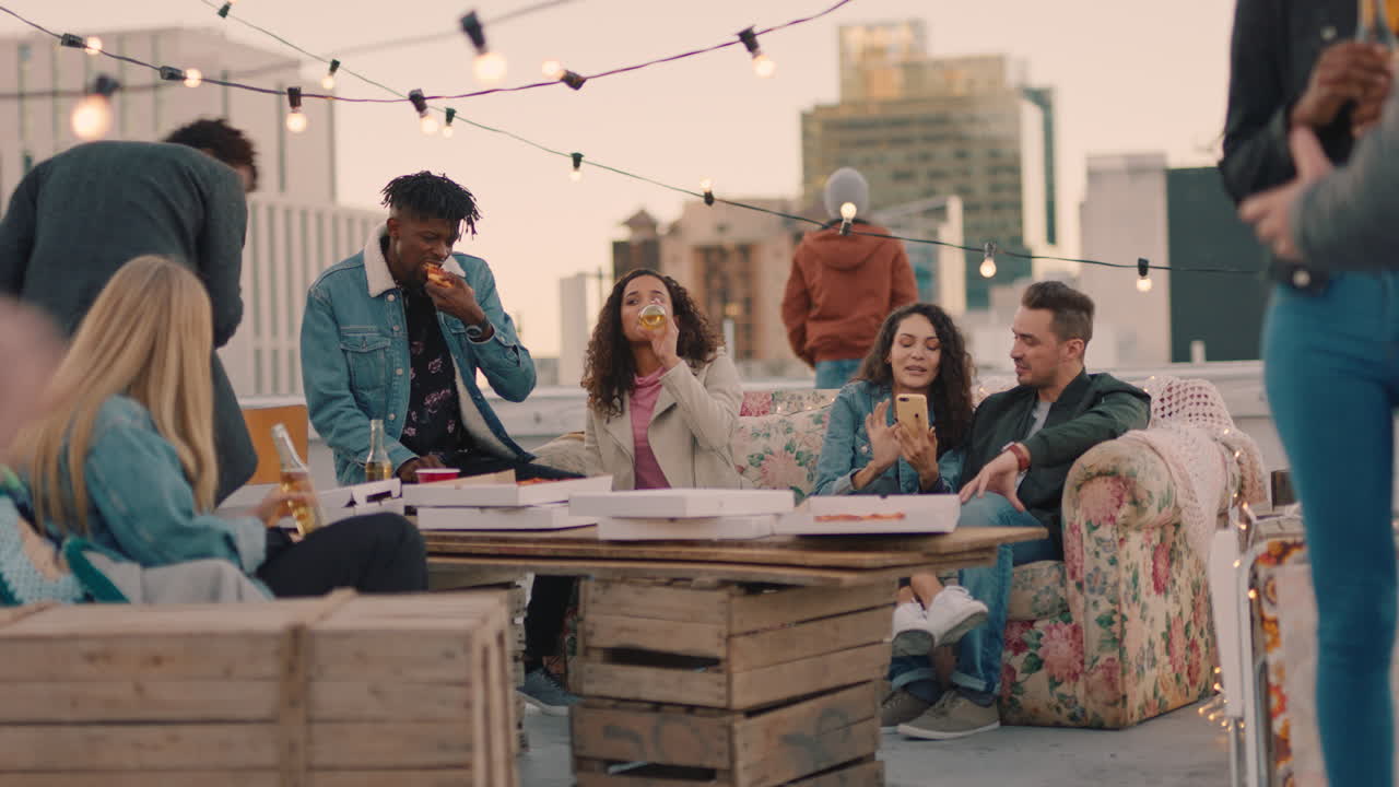 행복한 옥상 파티 친구들이 술을 마시고 주말에 즐겁게 지내고 사회적 모임에서 대화를 나누고 피자를 나누고 해가 지는 날 함께 어울리는 것을 즐기고