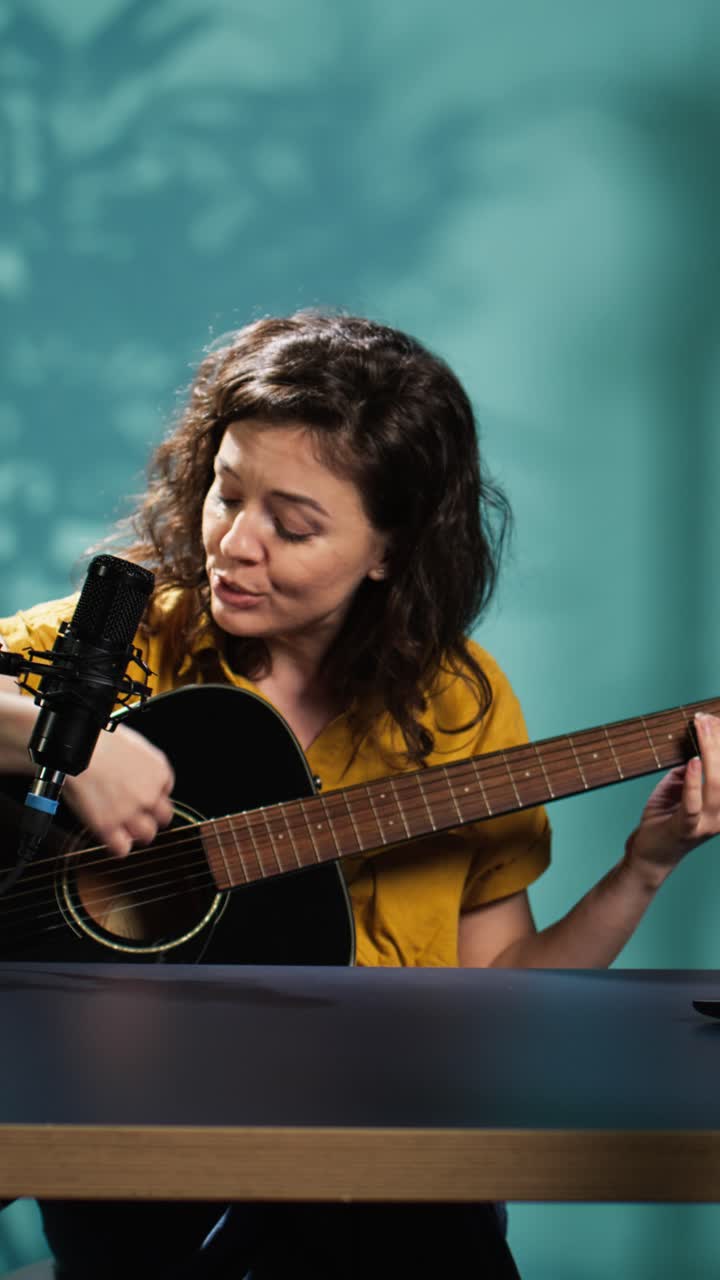 Kvinde der spiller akustisk guitar og synger i en mikrofon