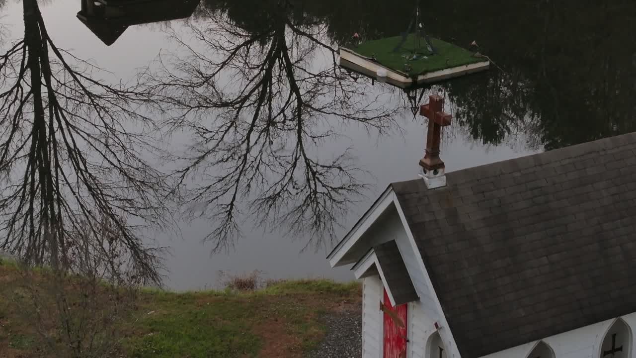 Aerial reveal of small buildings mirror effect from pond view