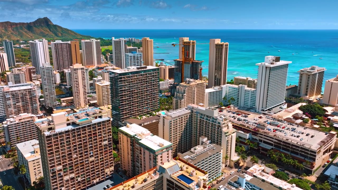 Volo sopra i grattacieli nel panorama di Waikiki, Honolulu, Hawaii, USA. Cratere di Koko Head e paesaggio marino color azzurro sullo sfondo. Vista aerea
