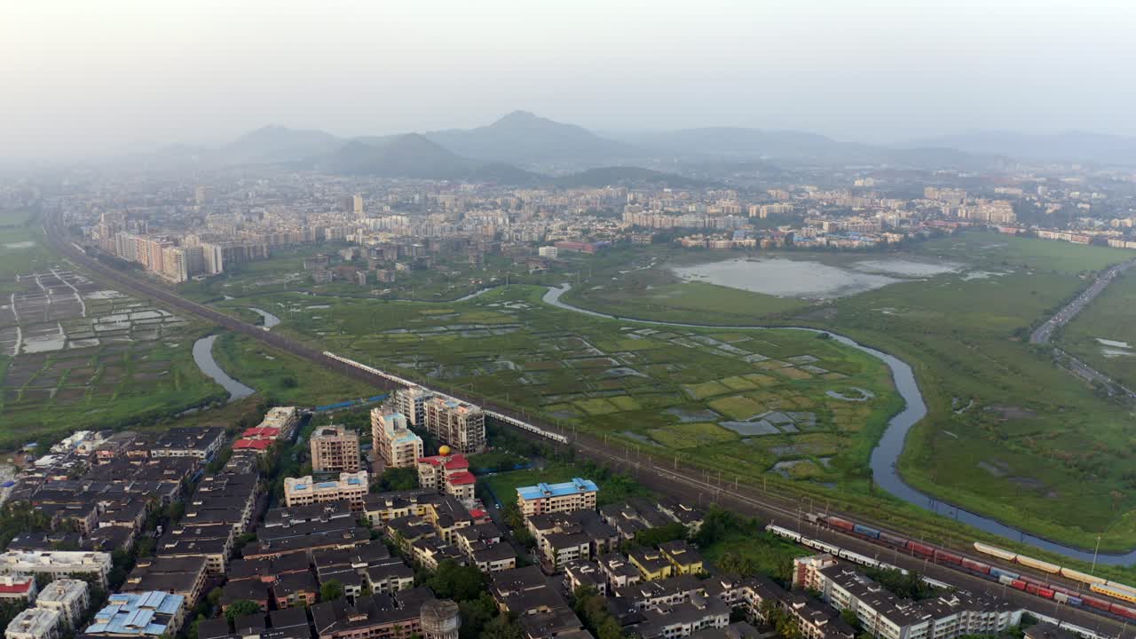 vista panorámica del paisaje urbano con líneas ferroviarias suburbanas en vasai, india - toma aérea de drones