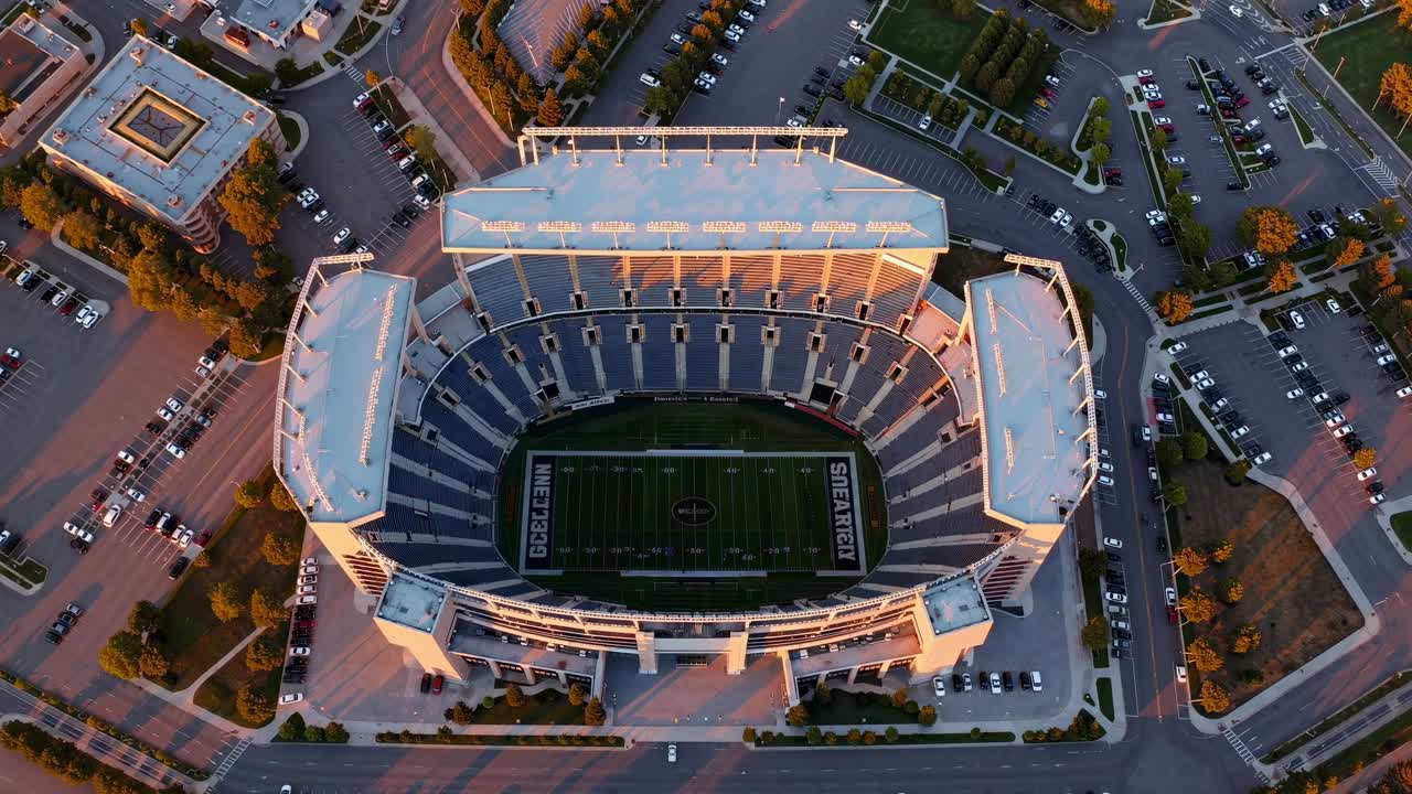 Aerial perspective of a contemporary stadium at dusk, highlighting the structure's design and the vibrant environment, evoking excitement and anticipation for upcoming events