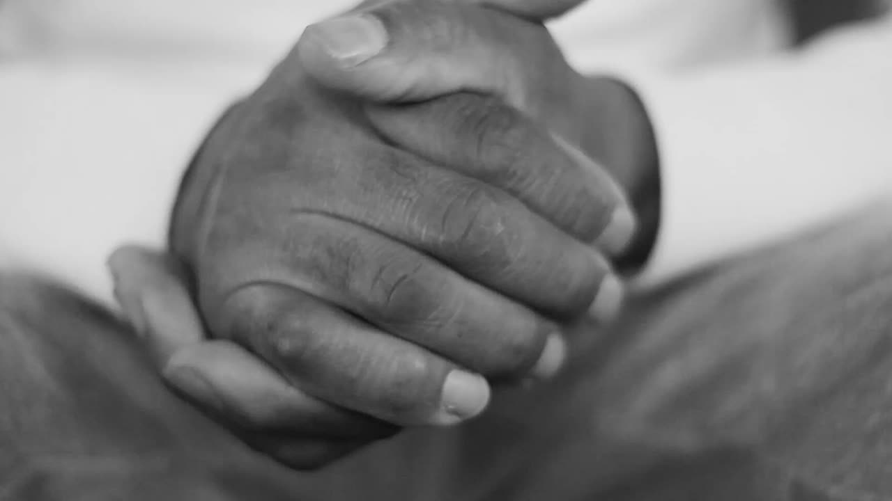 praying to God with hand's together with cross on table with people and black background stock video stock footage