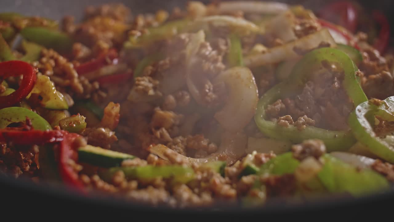 foto macro de carne y verduras en un wok, cocinando comida mexicana casera
