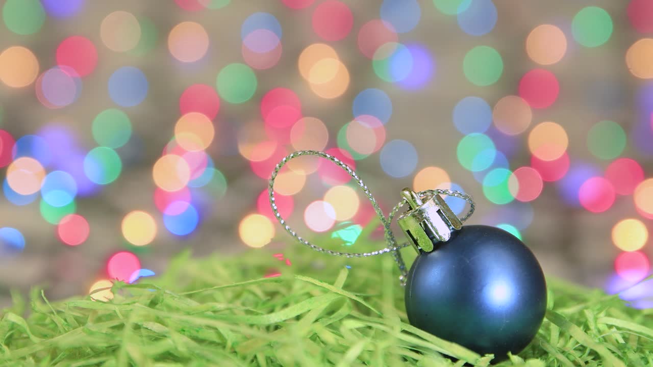 Blue Christmas ball on green tinsel, Christmas background, copy space.