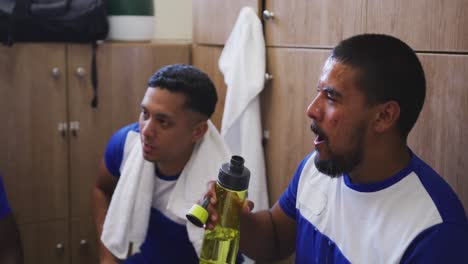 jugador de fútbol bebiendo agua en el vestuario