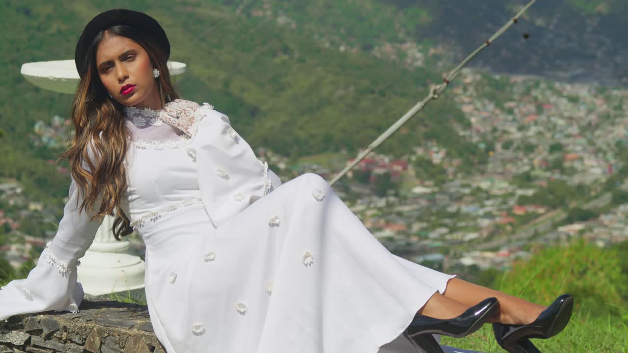 A young girl dressed in antique bridal attire on the grounds of a crumbling fortress.