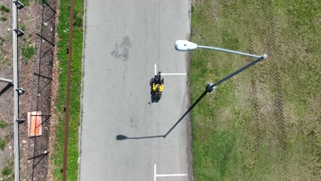 a top down view of a recumbent cyclist, riding in a park on a sunny day