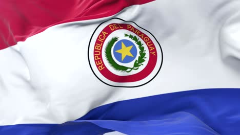 bandera de paraguay agitando en el viento con el cielo azul en lento, bucle