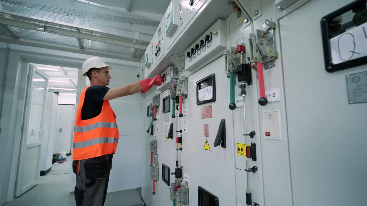 el ingeniero eléctrico que trabaja comprueba la tensión de corriente eléctrica y la sobrecarga en la parte delantera del gabinete del centro de carga o de la unidad de consumo para el mantenimiento en la sala principal del sistema de distribución de energía.