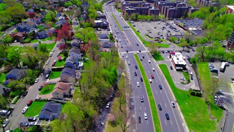 Drone-shot-capturing-a-lively-street-in-Yonkers,-NY,-with-residential-homes-and-busy-traffic