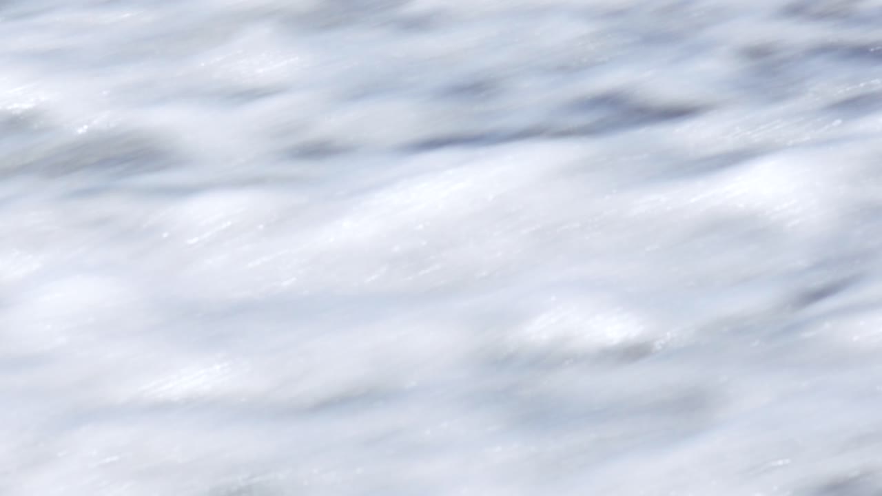 Dark ocean waves rippling over scenic volcano black sand beach coastline in Santorini Greece