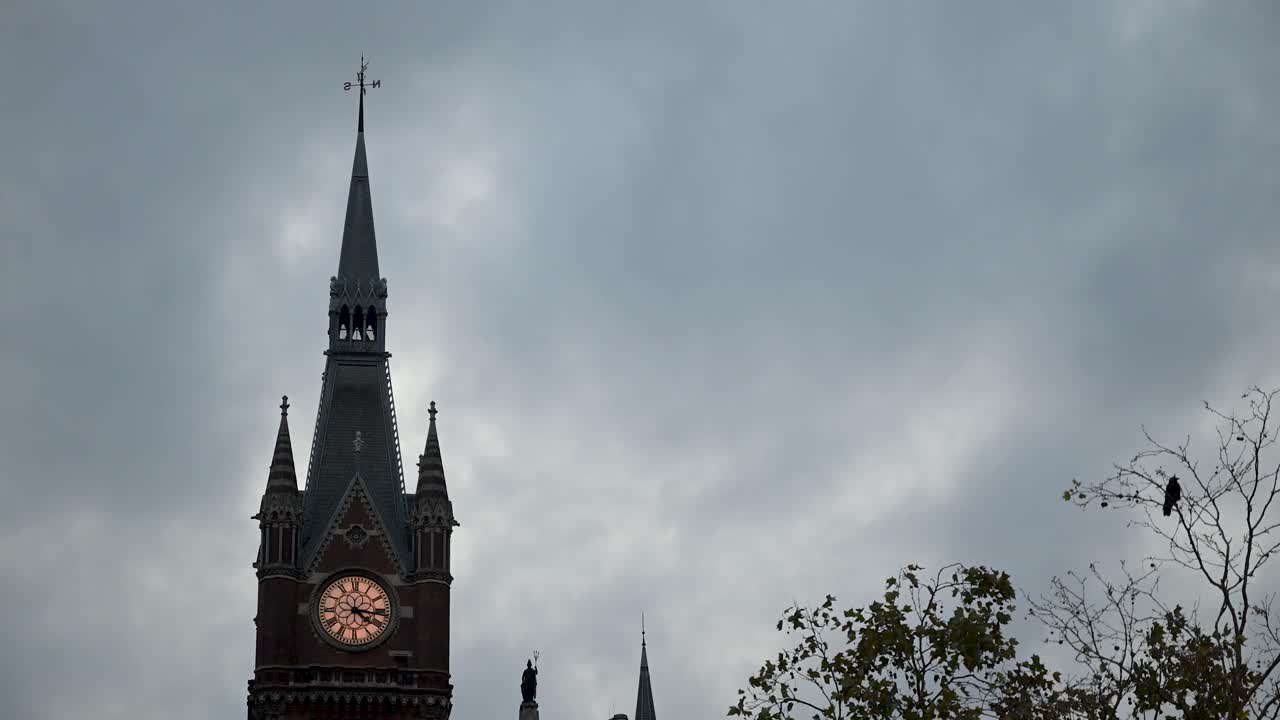 An evening view of the St Pancras clock tower glowing against the night sky, showcasing the iconic Victorian architecture and London’s timeless charm
