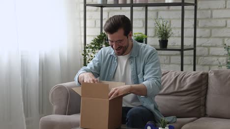 el hombre del milenio que abre la caja de paquetes se siente satisfecho con las mercancías entregadas