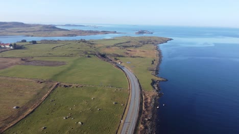 road e39 along norway coast is surrounded by green grasslands and going down into subsea tunnel byfjordtunnel - stavanger rogaland aerial