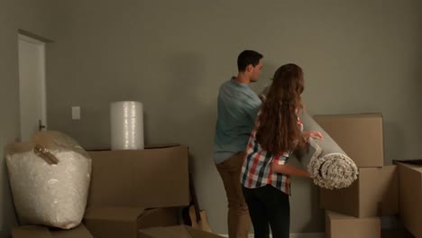 Happy-young-couple-holding-a-rug