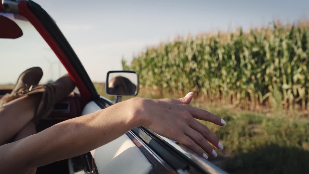 detalle de video de una mujer agitando la mano fuera del coche