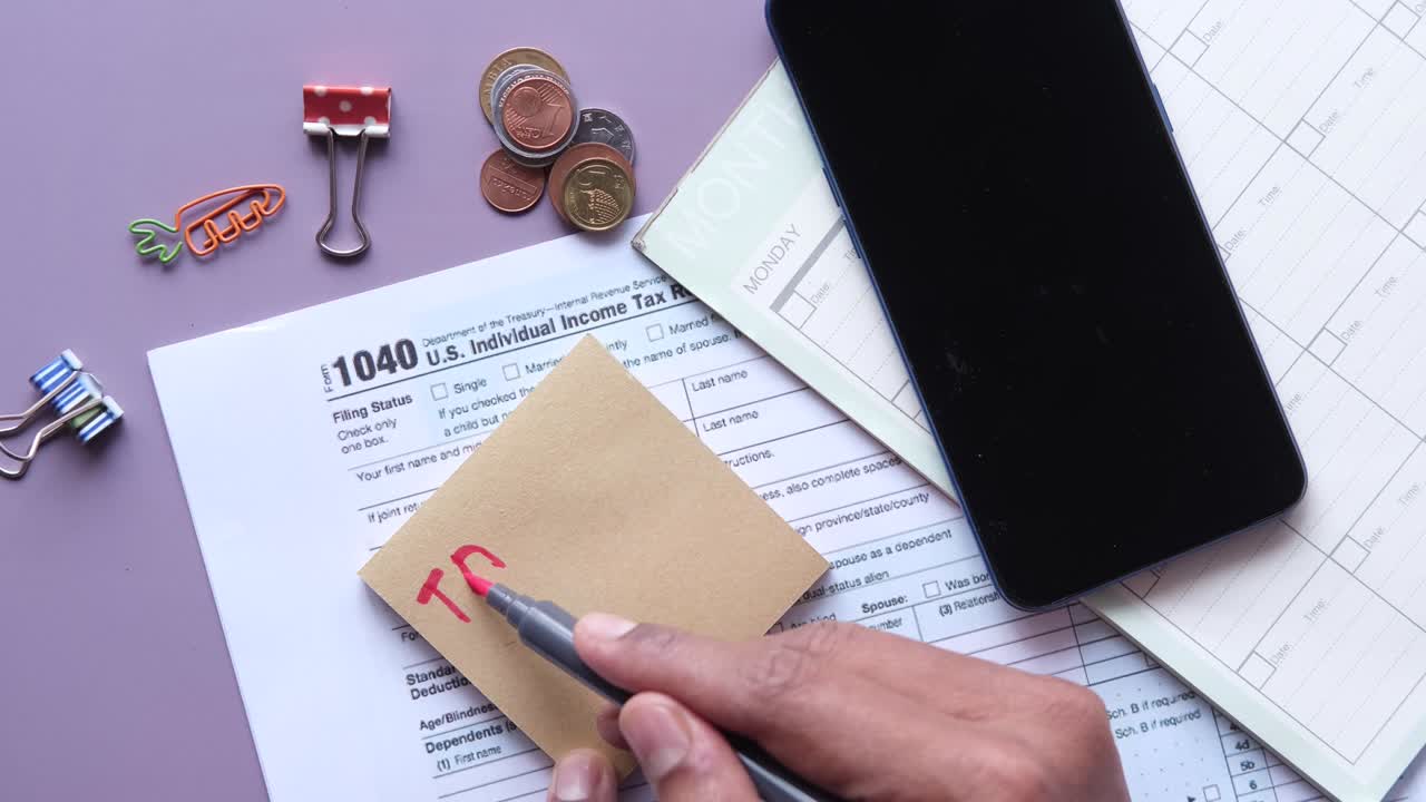 escribir el texto del impuesto adeudado en una nota adhesiva con el formulario de declaración de impuestos en la mesa